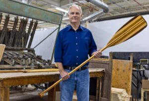 W. Graeme Roustan with a new Grey Owl paddle at the Roustan Sports factory